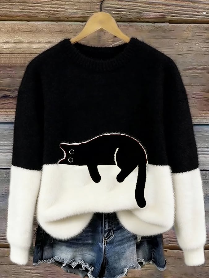 Fluffy jumper with black upper half, white lower half and black cat patch, on a hanger 5