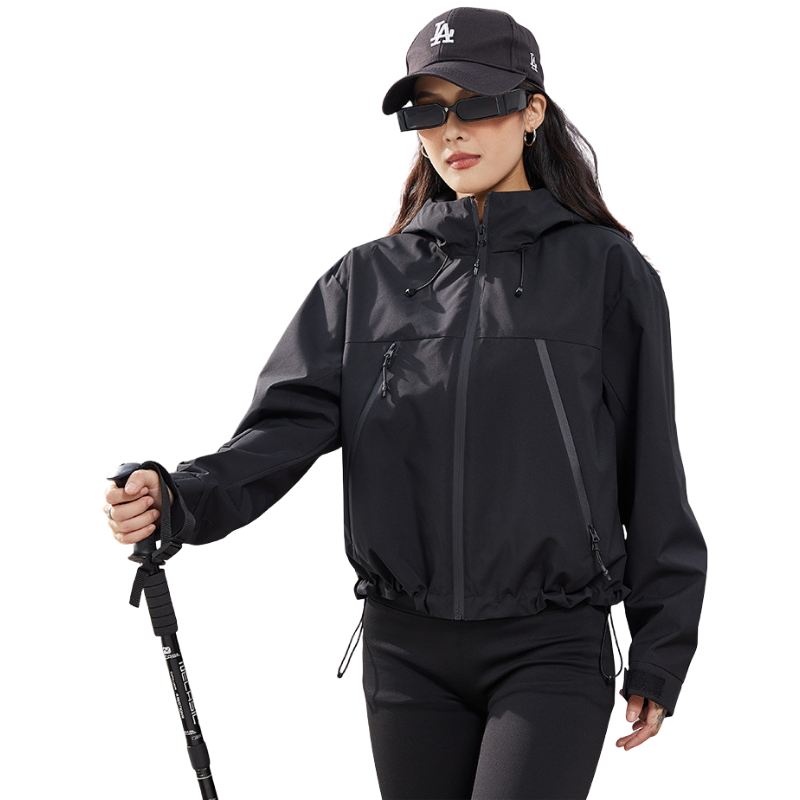 Black version of the jacket worn by a woman holding a trekking pole, hem drawcords gathered 14
