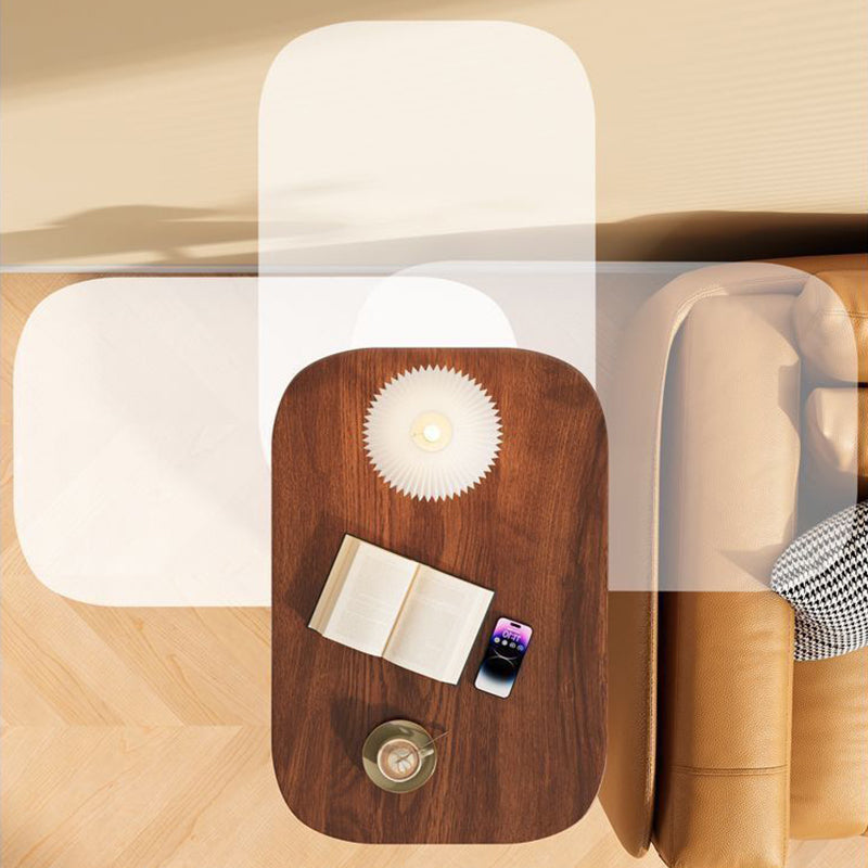 Overhead view of the walnut-effect top beside a tan leather sofa, holding a book, phone, lamp and cup, with ghosted positions showing its swivel. 7