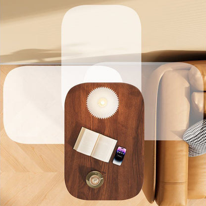 Overhead view of the walnut-effect top beside a tan leather sofa, holding a book, phone, lamp and cup, with ghosted positions showing its swivel. 7