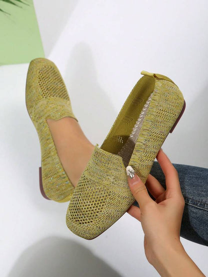 Olive-yellow mesh slip-ons, one held in a hand to show the inside, insole and heel tab. 19