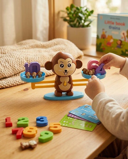 Child's hands placing a number on the brown monkey balance, with activity cards and loose numbers beside it 4