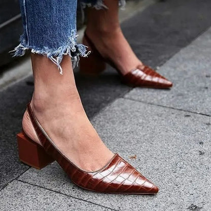 Brown croc-effect pointed slingbacks with chunky square heels, worn with frayed-hem jeans on paving 3