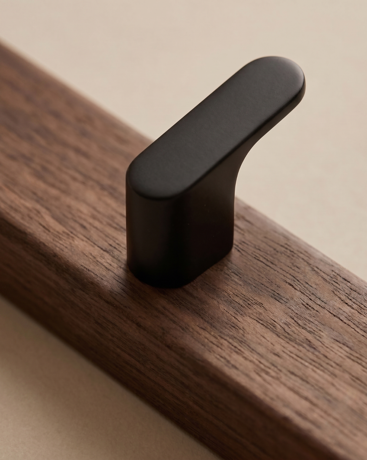 Close-up of one black hook fixed to the dark wood board, showing the grain 3