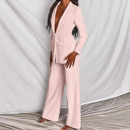 Pale pink blazer and wide-leg trousers shown from a three-quarter angle against draped grey fabric 3