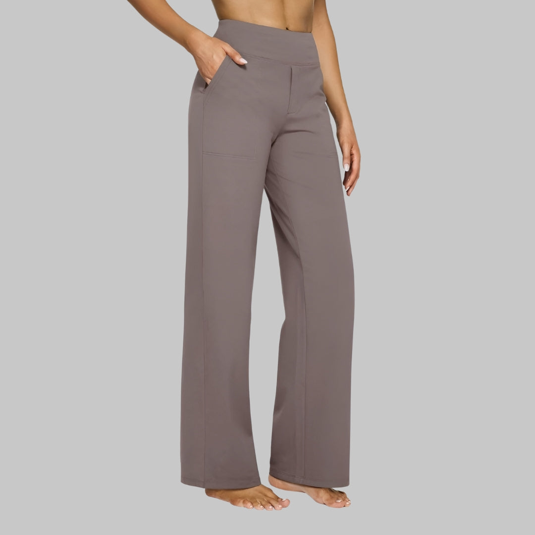 Model in taupe-grey high-waist trousers, side view, one hand in the pocket, showing the straight leg and patch pocket. 1