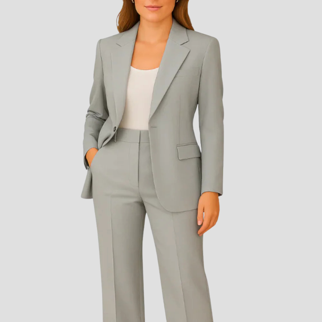 Model wearing the light grey suit with a white top, hand in pocket 4
