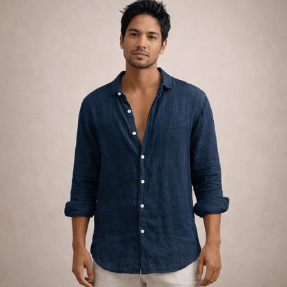 Model facing the camera in a navy linen shirt with a chest pocket, open collar and rolled sleeves. 12