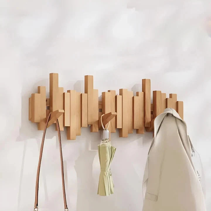Light natural wood rack with a brown leather-strap bag, a folded green umbrella and a cream coat hanging 5