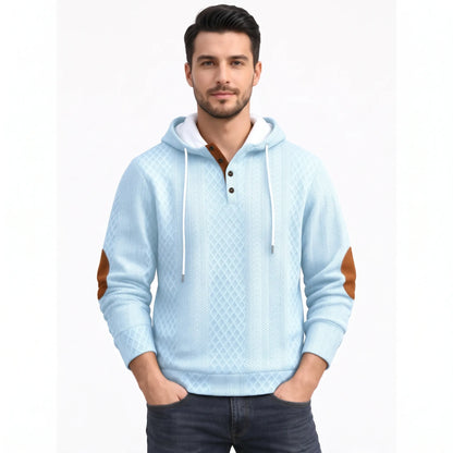 Model wearing the light blue version of the diamond-textured hoodie with tan elbow patches and contrast button placket 42