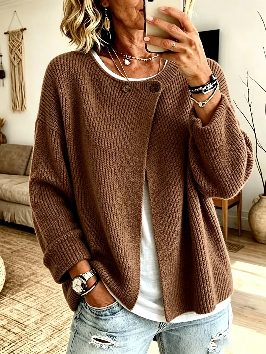 Front view of the cardigan in chocolate brown on a model taking a mirror selfie, with two buttons at the neckline 4