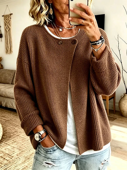 Front view of the cardigan in chocolate brown on a model taking a mirror selfie, with two buttons at the neckline 4