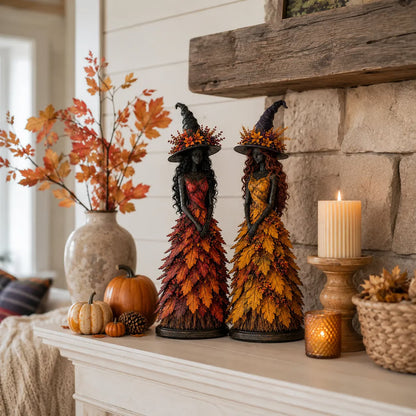 Red and golden-orange witch figurines on a white mantelpiece with a vase of autumn branches, pumpkins, a pine cone and candles. 6