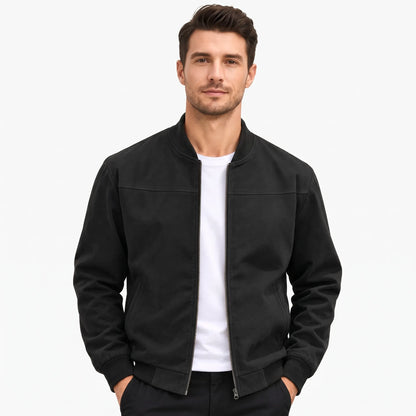 Studio shot of a model in the black jacket, zip open, hands in trouser pockets 49