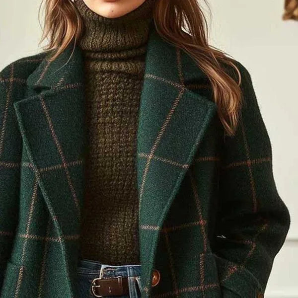 Close-up of the dark green coat's wide notched lapels and fine check pattern over a knitted polo neck 4