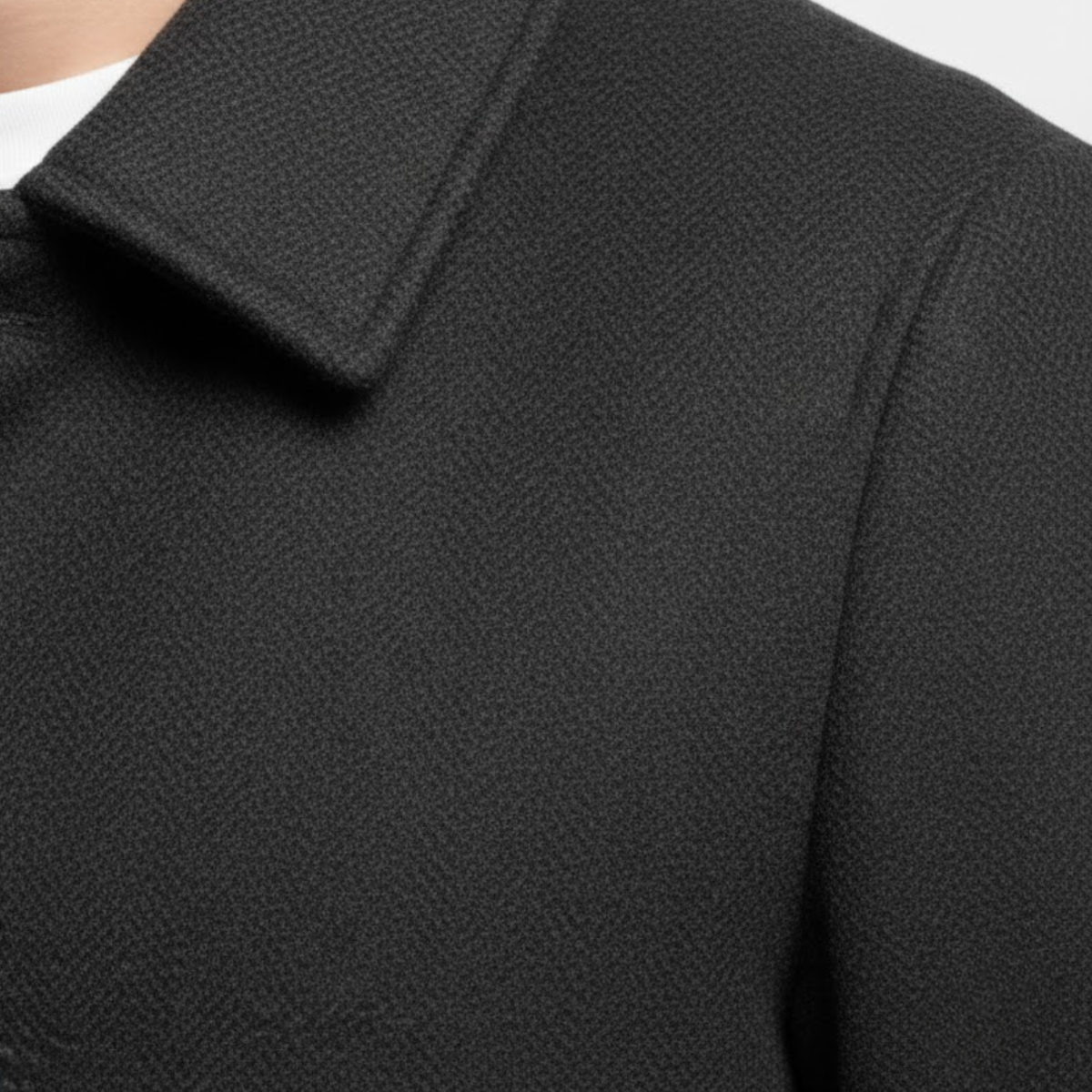 Close-up of the notch lapel and shoulder, showing the fine woven texture of the dark fabric 7