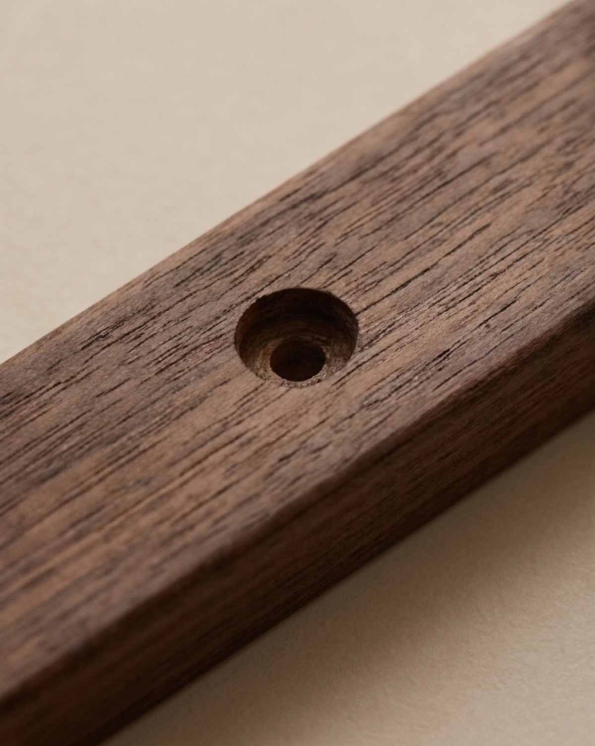 Close-up of a countersunk screw hole in the dark wooden board, showing the wood grain 4