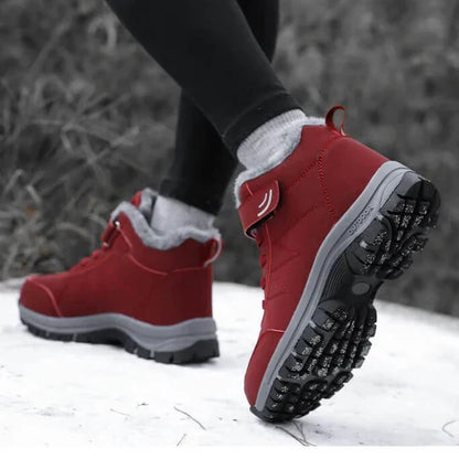 Person walking in red fleece-lined boots on snow, raised heel showing the chunky tread 6
