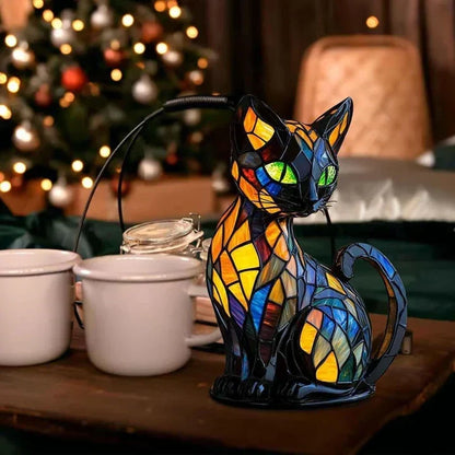 Glowing stained-glass cat lamp on a wooden table beside white mugs, with a lit Christmas tree behind 3