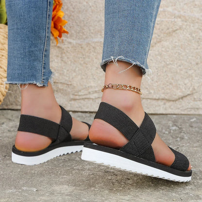 Rear view of black sandals on a model, showing the elastic heel straps and ridged white sole 4
