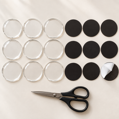 Nine clear round acrylic blanks with nine black round magnet sheets and a pair of scissors on a cream background 10