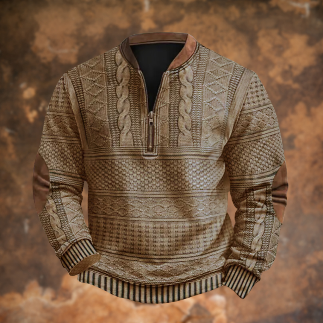 Front view of the light brown, sand-toned version with cable and diamond knit panels, half zip and tan elbow patches, on a rusty backdrop. 3