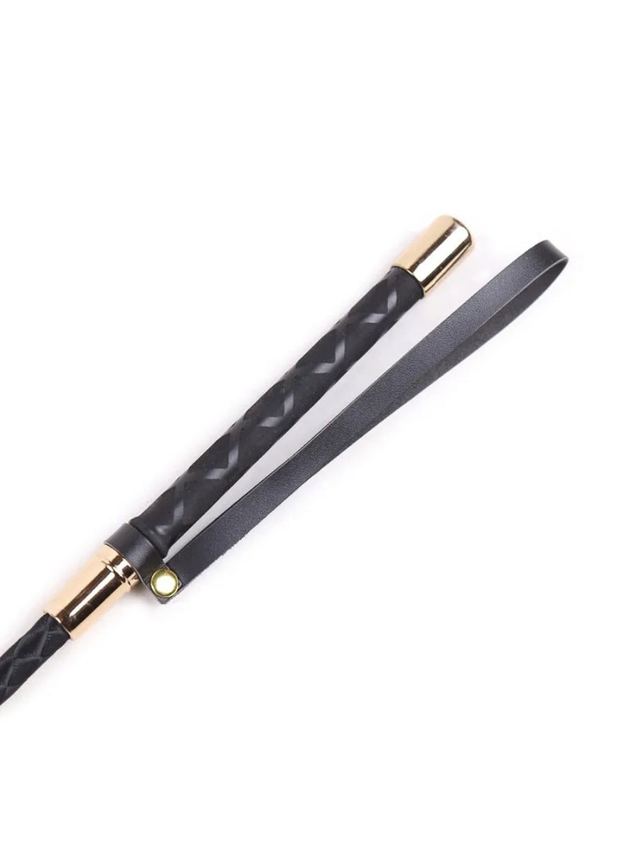 Close-up of the handle end with gold-toned metal collars, a stitched grip and a black strap loop fastened by a gold stud. 3