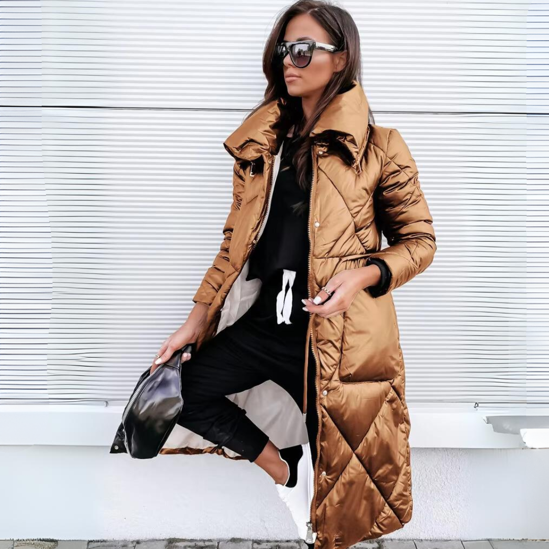 Same long quilted puffer coat in a glossy bronze-brown shade, worn open by a woman with sunglasses and a black bag. 2