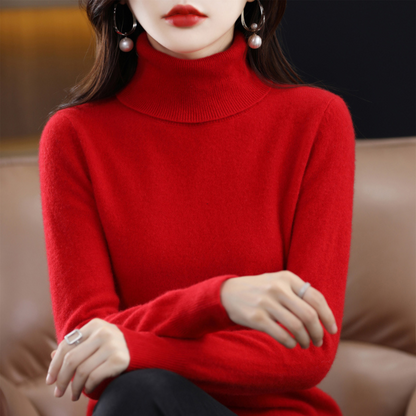 Vivid red roll-neck jumper on a seated model with crossed forearms, showing the thick ribbed collar and fitted sleeves. 9