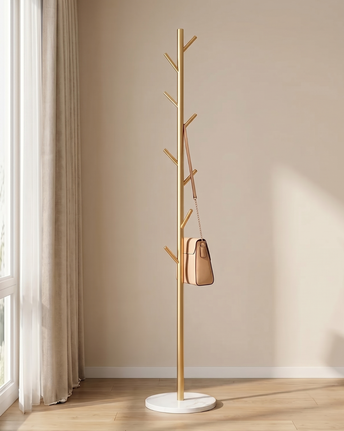 Gold-coloured version of the rack with a white round base and a tan handbag hanging from a hook, by a window. 4