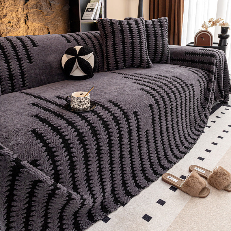 Dark grey cover with black zigzag stripes on a sofa, with cushions, a teacup and slippers on a rug 13