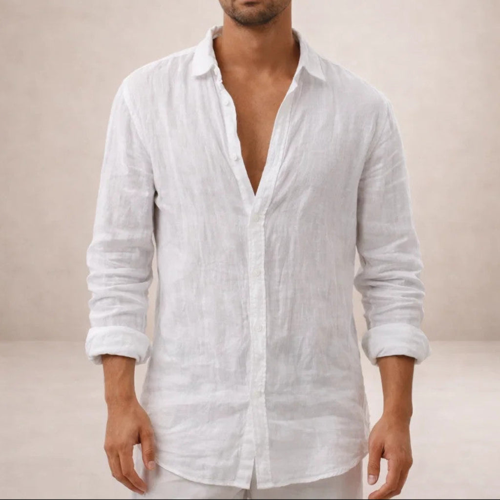 White linen shirt worn open at the collar by a model, cropped at the chin, with sleeves rolled to the forearms. 3
