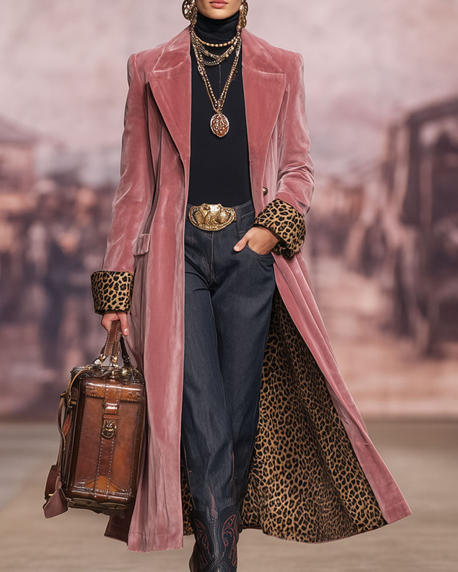 Model on a runway-style set in the pink coat, hand in pocket, leopard lining visible and a brown leather case in hand. 3