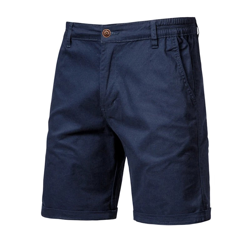 Front view of the shorts in navy blue, with a brown button, side pockets, elasticated waist and cuffed hems. 10