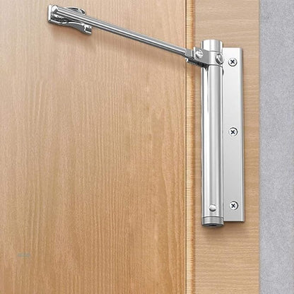 Polished silver closer mounted on a natural wood door and frame, arm angled upwards 2