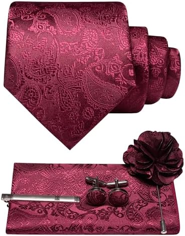 Burgundy paisley tie rolled above matching pocket square, cufflinks, tie clip and flower lapel pin laid out as a set. 1