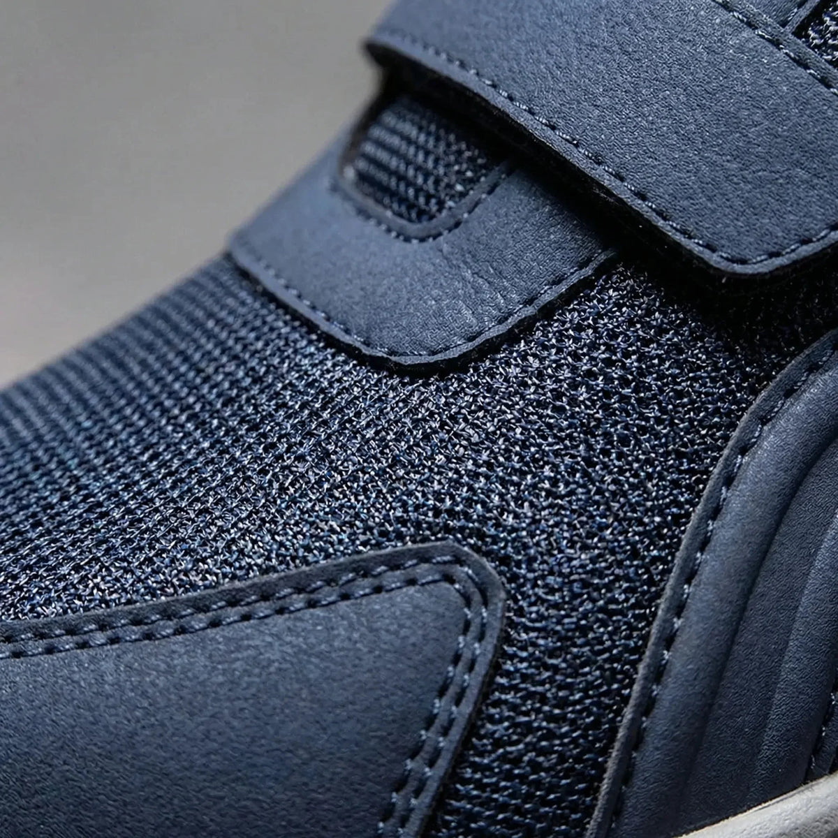 Close-up of the navy mesh upper, stitched strap and smooth overlay panel 10