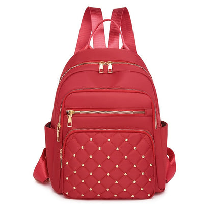 Red backpack front view with a quilted, gold-studded front pocket and gold zips 16