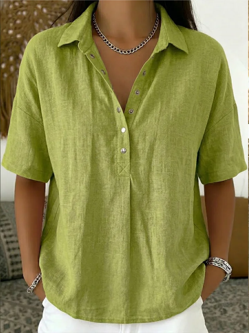 Model wearing the short-sleeved blouse in lime green, with metal snap buttons and a chain necklace 4