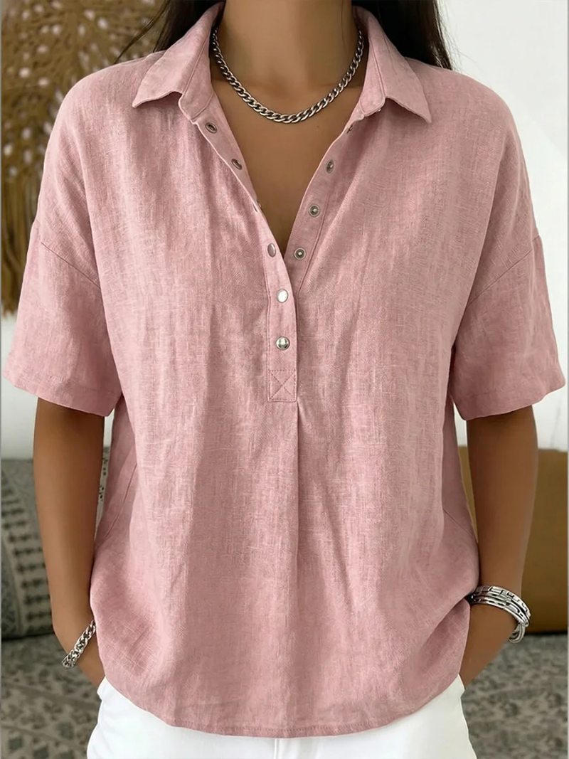 Model wearing the short-sleeved blouse in dusty pink, with metal snap buttons and a chain necklace 5