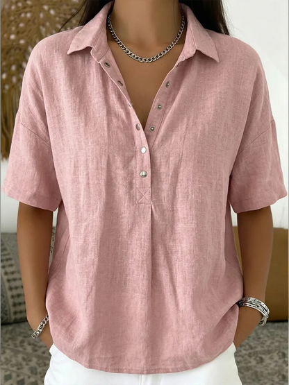 Model wearing the short-sleeved blouse in dusty pink, with metal snap buttons and a chain necklace 5