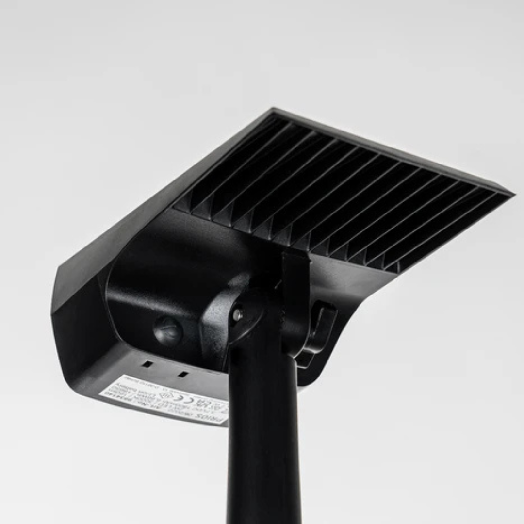Underside of the black spotlight head showing the ribbed back, the pivoting joint on the stake and a rating label. 5