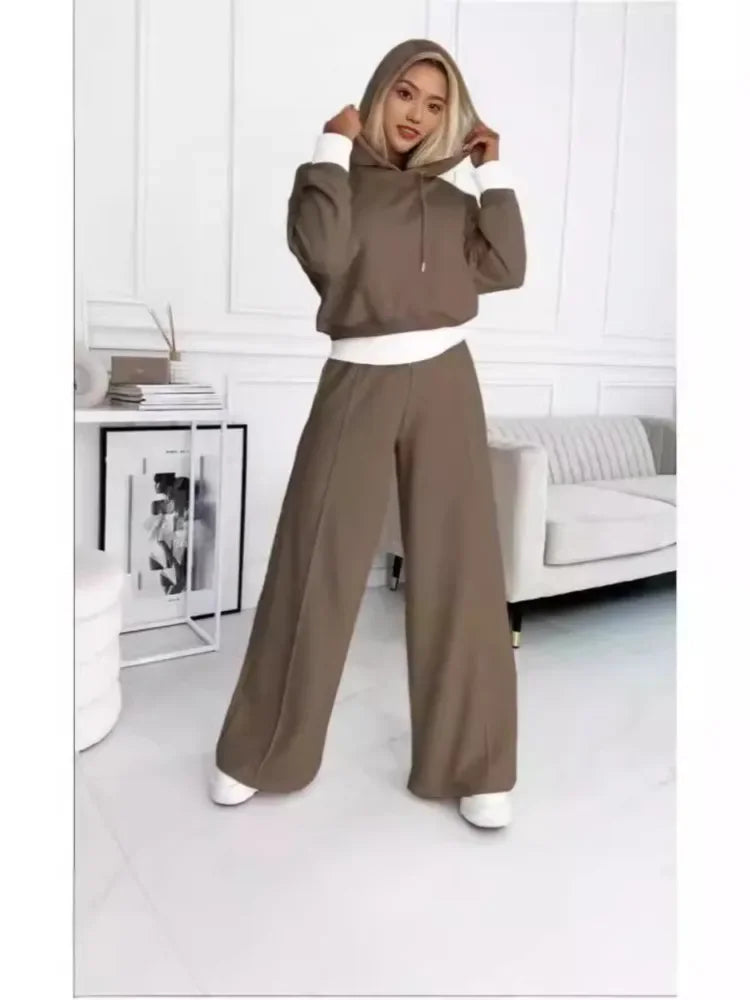 Full-length view of the brown set with white cuffs and hem, hood pulled up by the model 5