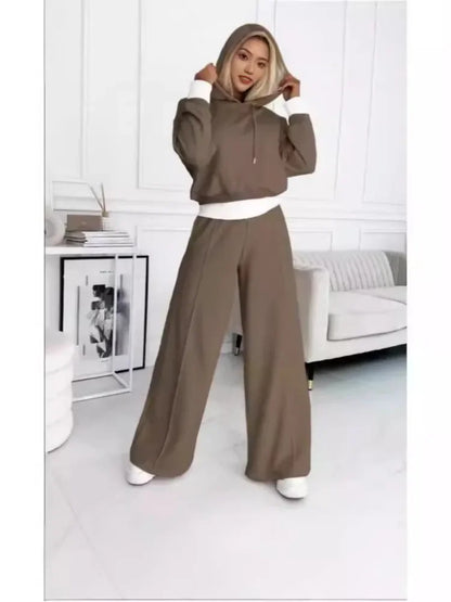Full-length view of the brown set with white cuffs and hem, hood pulled up by the model 5