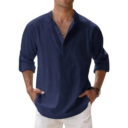 Man wearing the Henley shirt in navy blue, with a short button placket, rolled sleeves and hands in white trousers. 5