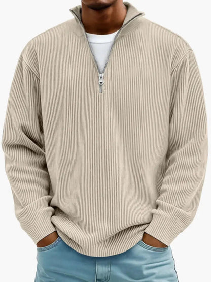 Man wearing the ribbed quarter-zip jumper in beige over a white tee, hands in the pockets of light blue jeans. 4