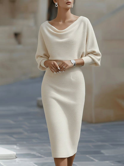 Model wearing the midi dress in cream, front view, with draped boat neckline, wide sleeves and a slim pencil skirt. 3