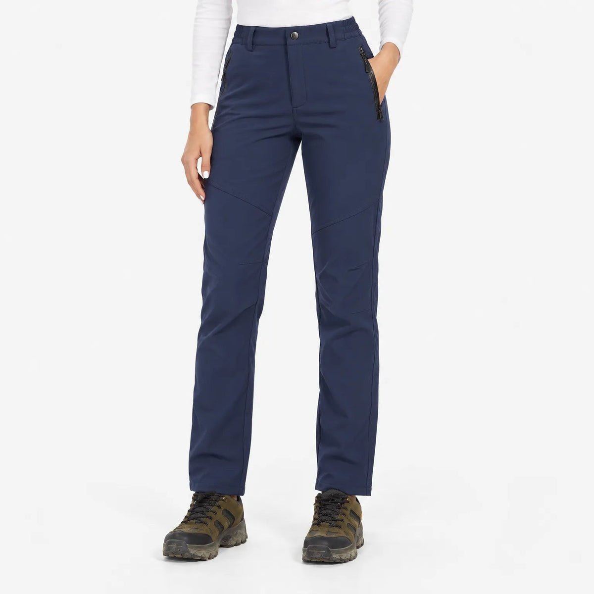 Navy trousers worn by a model in a studio, front view with hand in zipped pocket 3