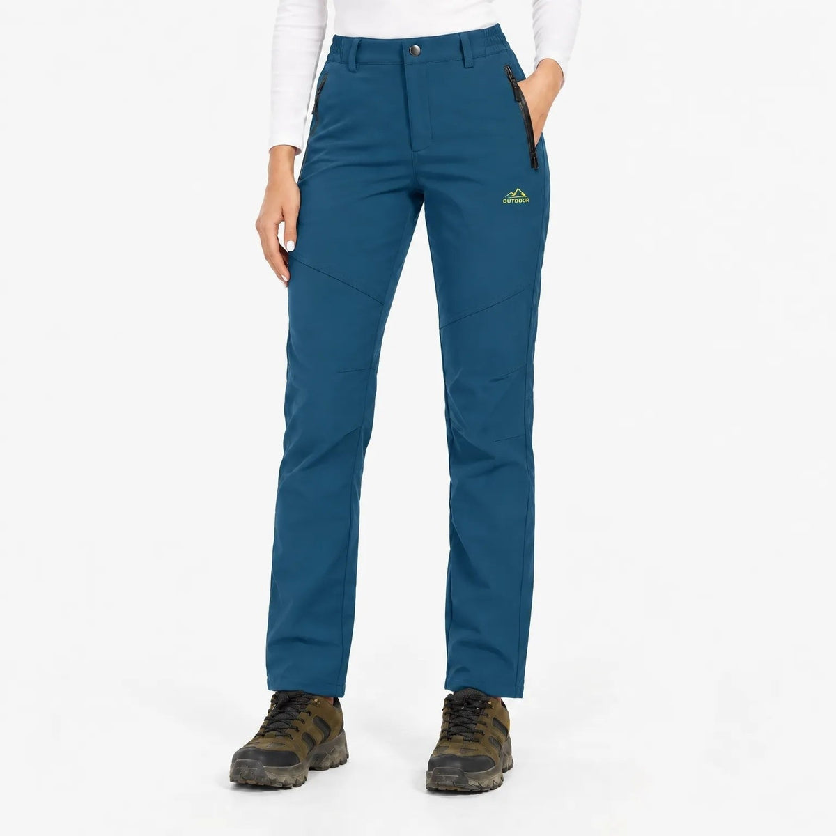 Deep teal blue trousers worn by a model, front view with zipped pockets and hiking boots 20