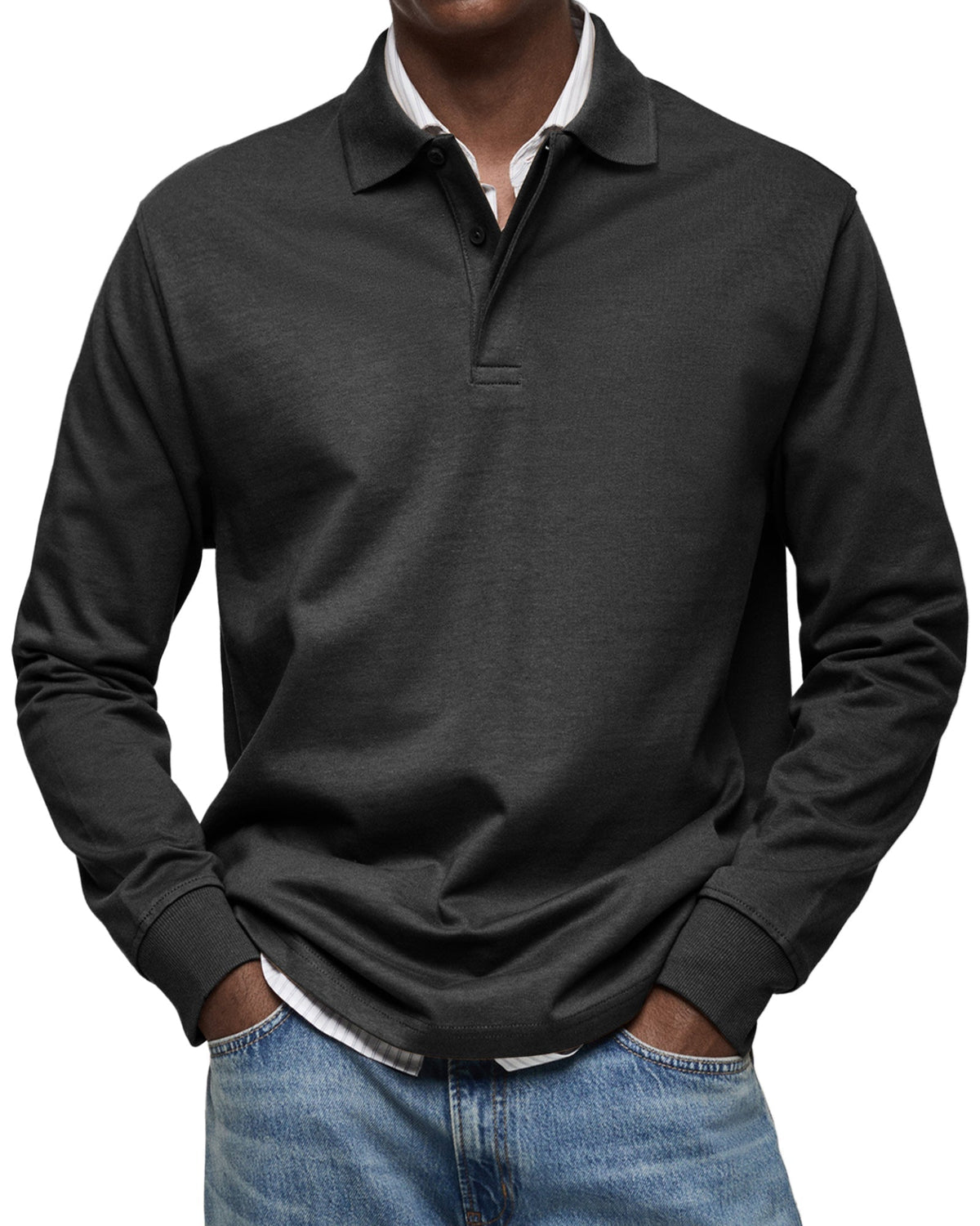 Model wearing the polo in black, three-button placket and ribbed cuffs, layered over a striped shirt with jeans. 4